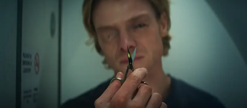 TOM RHYS HARRIES holds a pair of scissors as Matt Hagen in a still from DC Studios’ movie “Clayface"