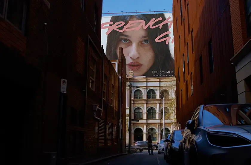 Mia Kudis looks French-like on a billboard in the film French Girls, from writer-director Hyun Lee whom we interview