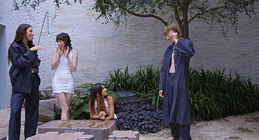Four models hang out in a courtyard in a still from the film French Girls, from writer-director Hyun Lee whom we interview